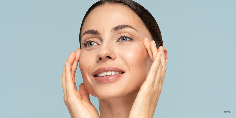 Female touching her face with both hands.